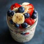 Banana berry overnight oats in a mason jar with fresh fruit toppings