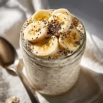 Creamy vanilla protein overnight oats in a glass jar with banana and chia seeds