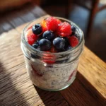 Overnight oats with water in a glass jar topped with berries